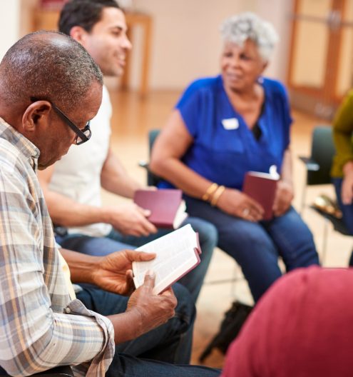 People Attending Bible Study Or Book Group Meeting In Community Center