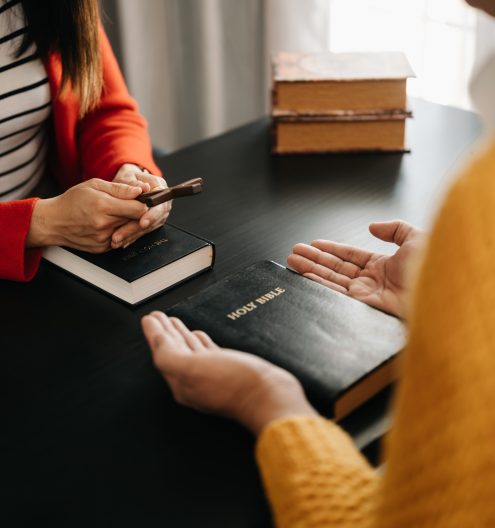 Two people reading and study bible in home and pray together.Studying the Word Of God With Friends.
